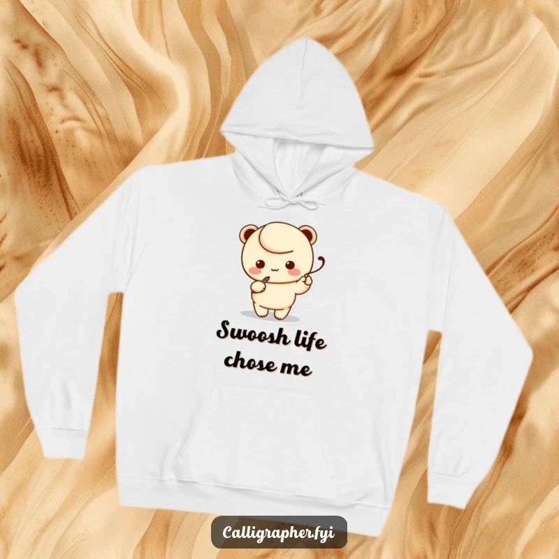 Funny hoodie showcasing a kawaii character artist holding a calligraphy pen, gracefully writing a swoosh, perfect for cozy creative sessions.